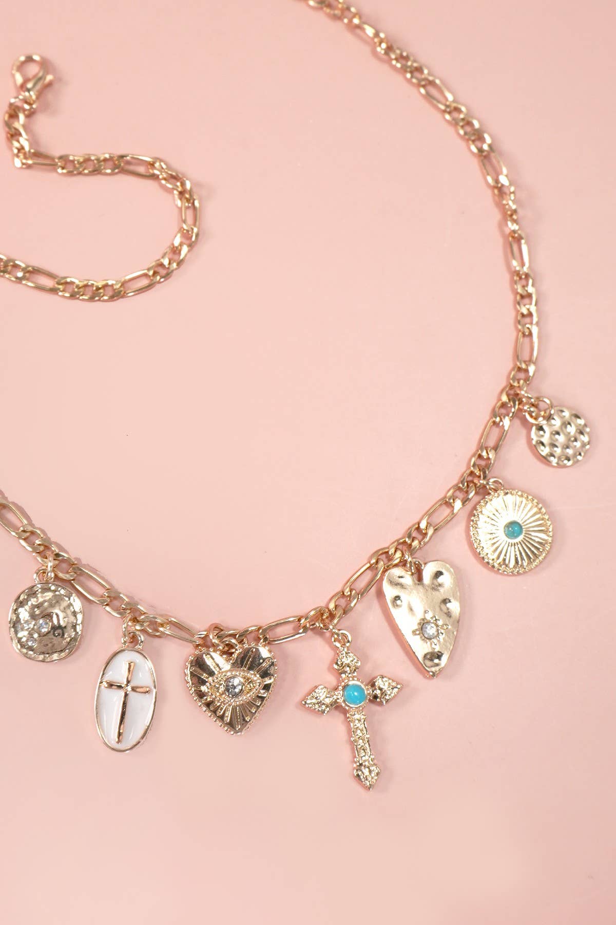 Gold charm statement necklace featuring multiple crosses, a heart, and sparkling rhinestones and turquoise.  