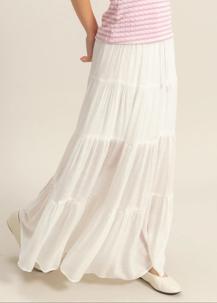 White tiered maxi skirt with a smocked elastic waistband and ankle-skimming hem.