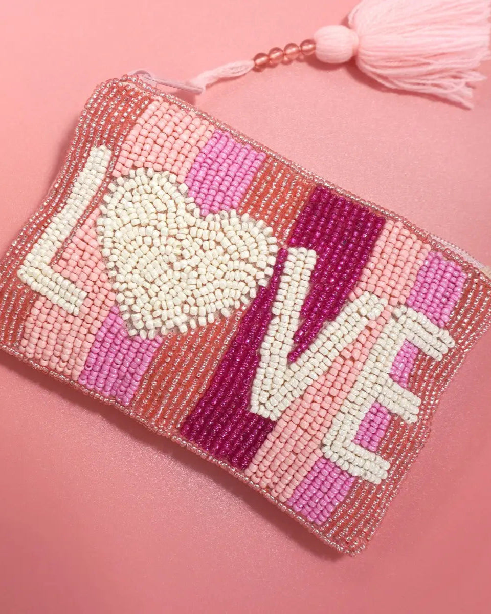 Pink seed bead coin purse with "Love" motif, zipper closure, and tassel detail.