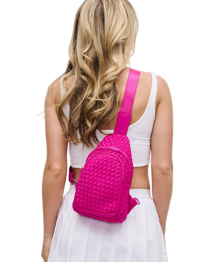 Woven neoprene women's sling backpack in Fuchsia with adjustable strap and zippered compartments.