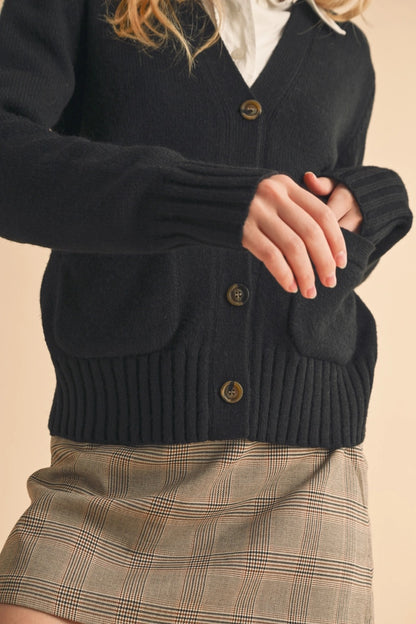 Black button-up cardigan with front pockets and a slightly oversized fit.