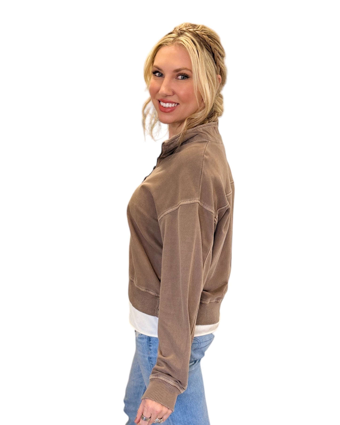 Woman smiling and wearing jeans with the Mocha French Terry Half-Zip Sweatshirt made from 100% cotton with a washed finish, featuring a half-zip design, ribbed hem and cuffs, and a relaxed fit for casual styling.