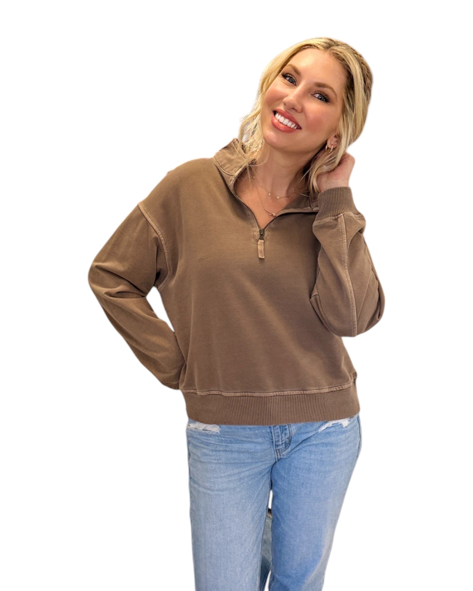 Woman smiling and wearing jeans with the Mocha French Terry Half-Zip Sweatshirt made from 100% cotton with a washed finish, featuring a half-zip design, ribbed hem and cuffs, and a relaxed fit for casual styling.