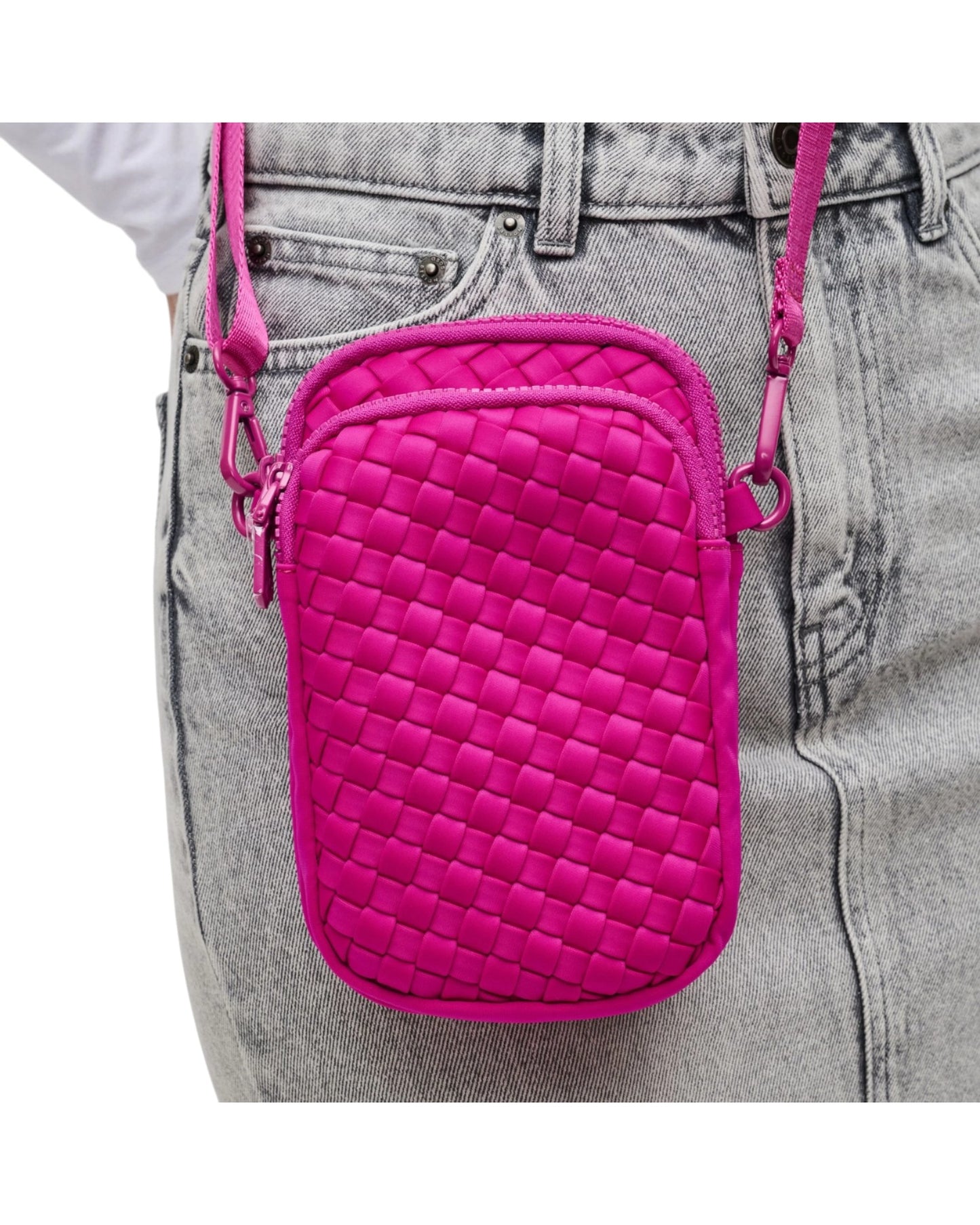 Compact neoprene cell phone crossbody bag with three zippered compartments and adjustable strap in Fuchsia.