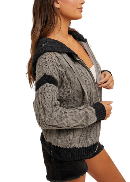 Women's color-block cable knit hoodie sweater with zippered front, soft cotton blend, and cozy hood in gray and black. 