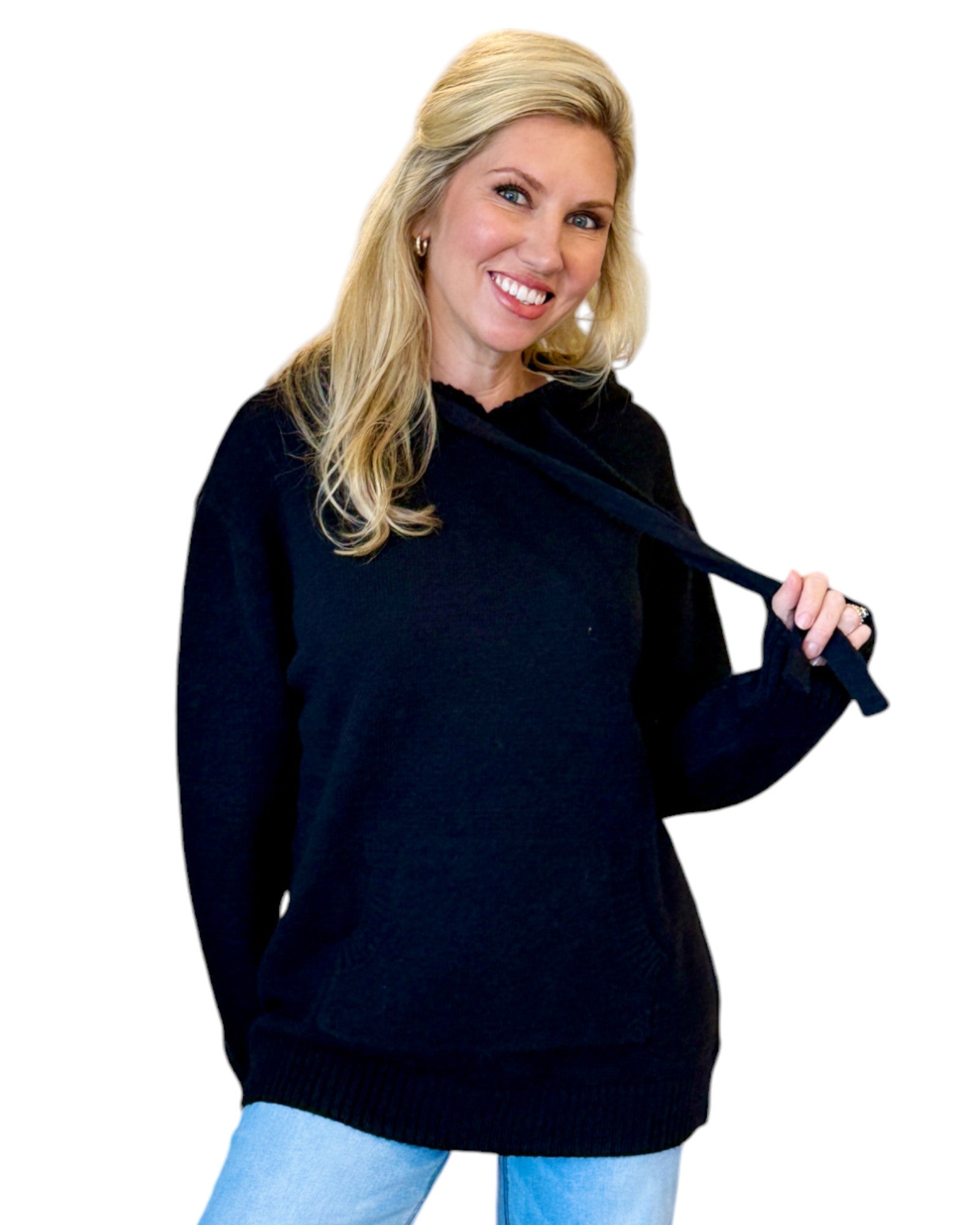 Woman wearing a soft, black oversized hoodie sweater.