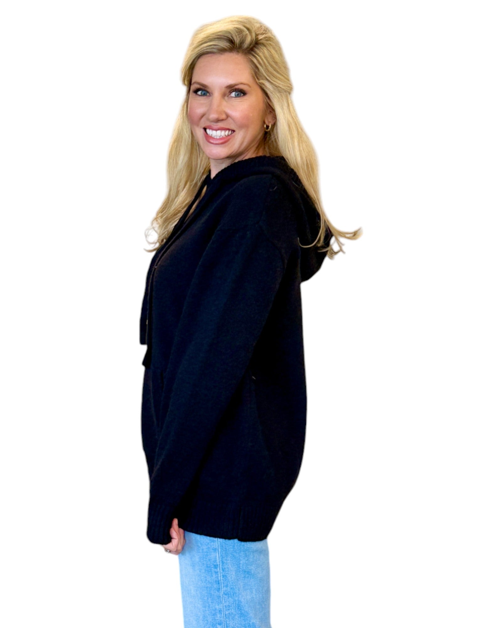 Woman wearing a soft, black oversized hoodie sweater.