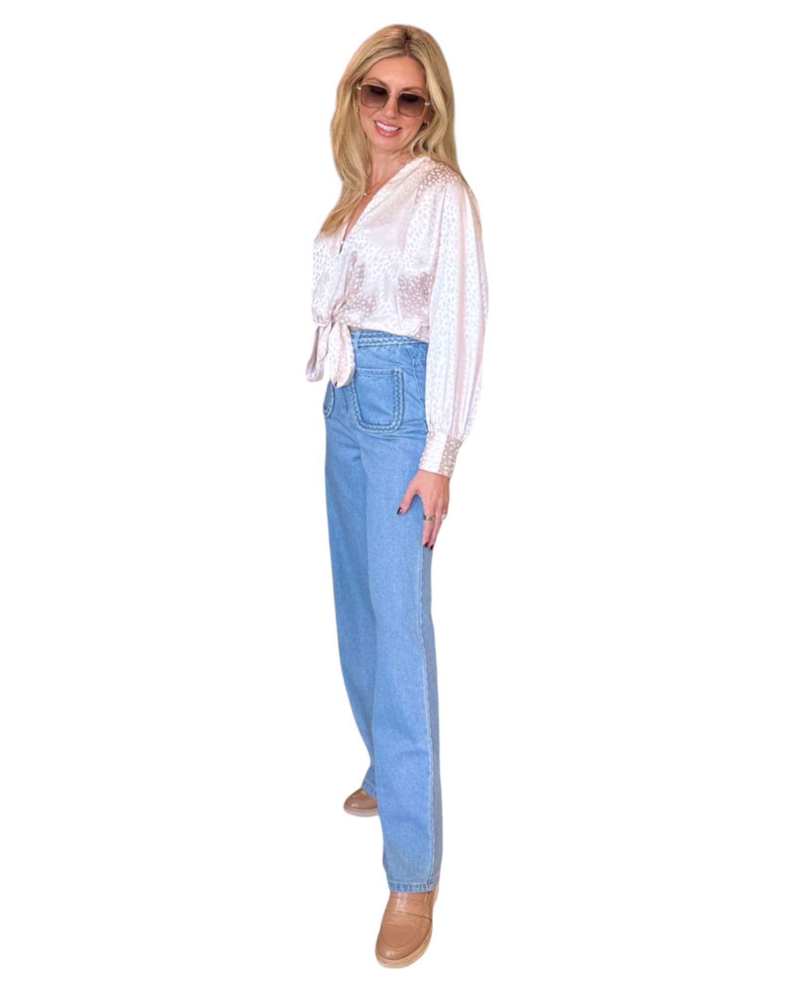 High waist blue denim jeans with braided waistband detail, straight wide-leg fit, and extra-high waist. Made from no-stretch fabric with front pockets and a longer inseam, ideal for a slender silhouette. Medium blue washed denim.