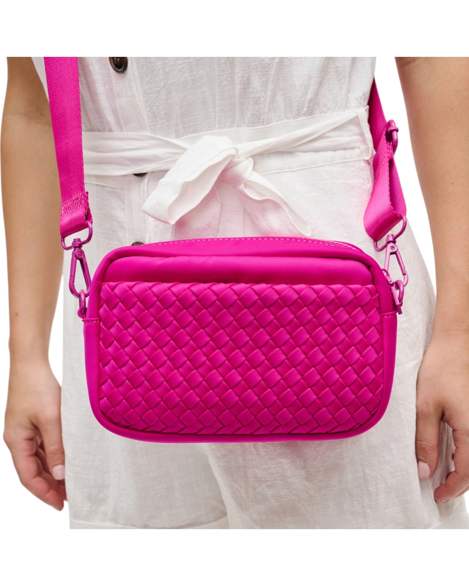 Woven neoprene crossbody bag with adjustable strap, top zip closure, and convenient side pockets.