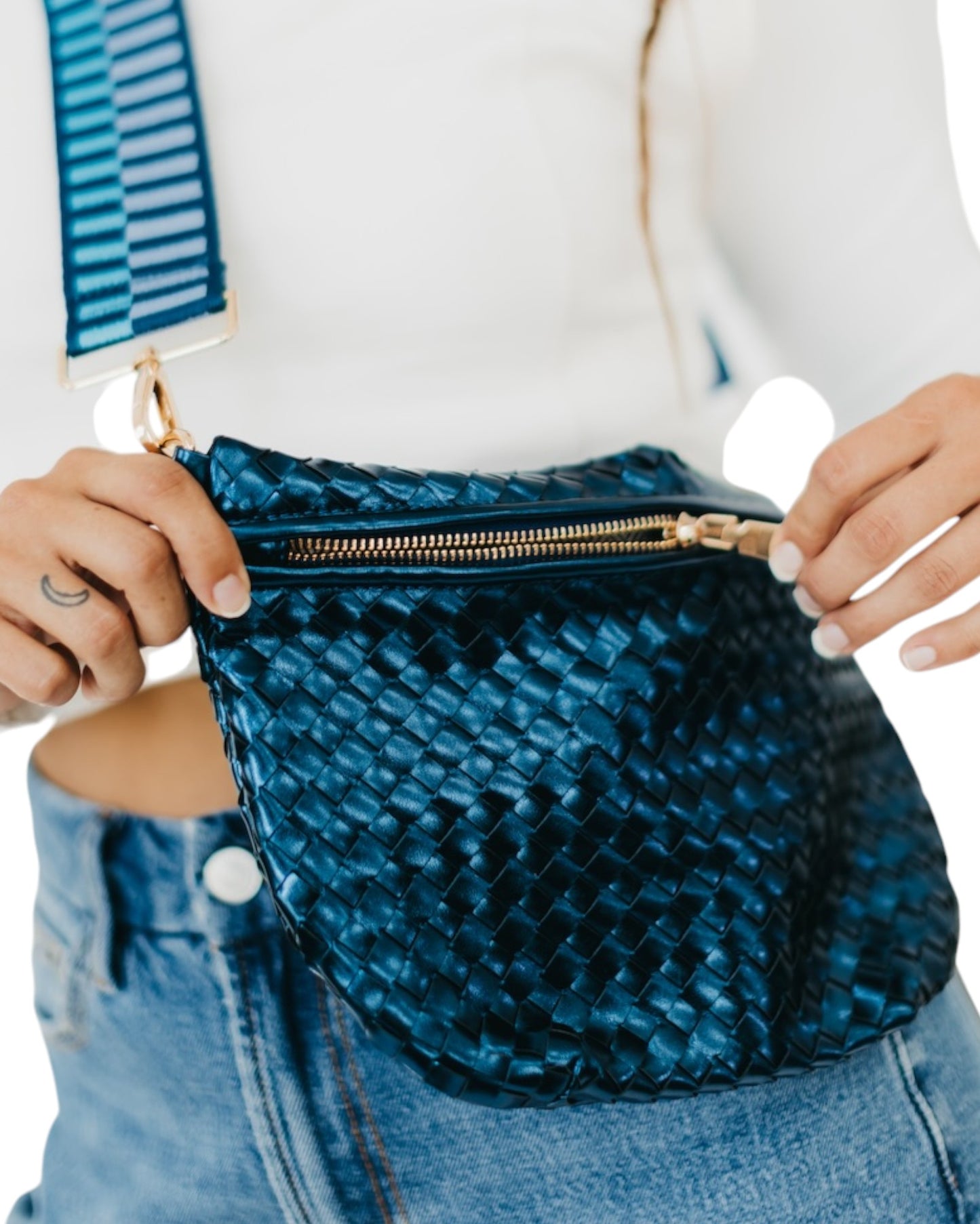 Navy blue metallic woven crossbody bag with gold hardware, adjustable strap, and chevron lining.