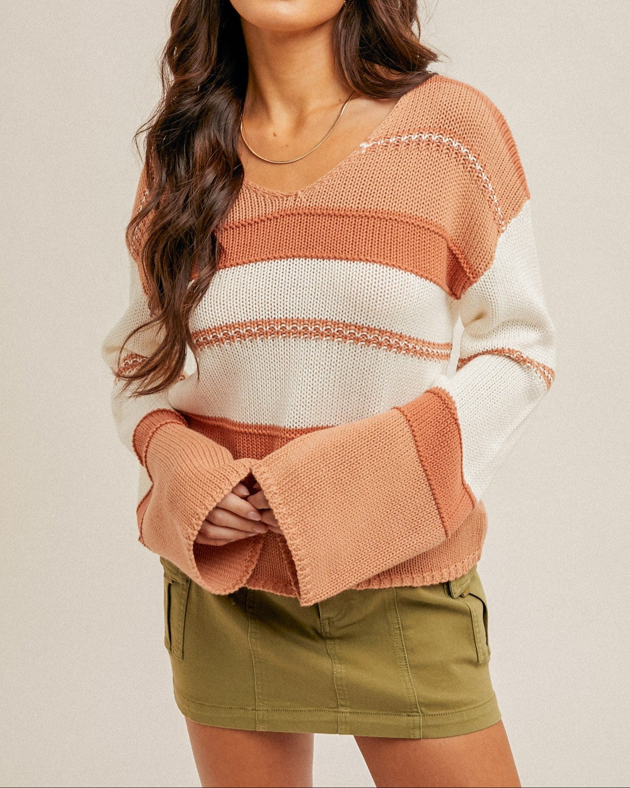 Sienna and cream striped knit sweater with a soft V-neckline and oversized sleeves.