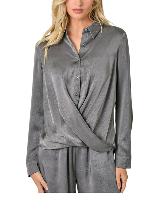 Woman wearing a grey button up crinkle satin twist front blouse. 