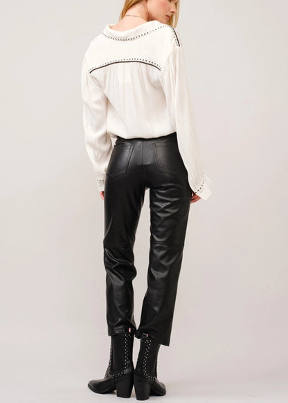 White crepe blouse with studded details, black piping on shoulders, classic collar, and slit neckline with hook closures. 