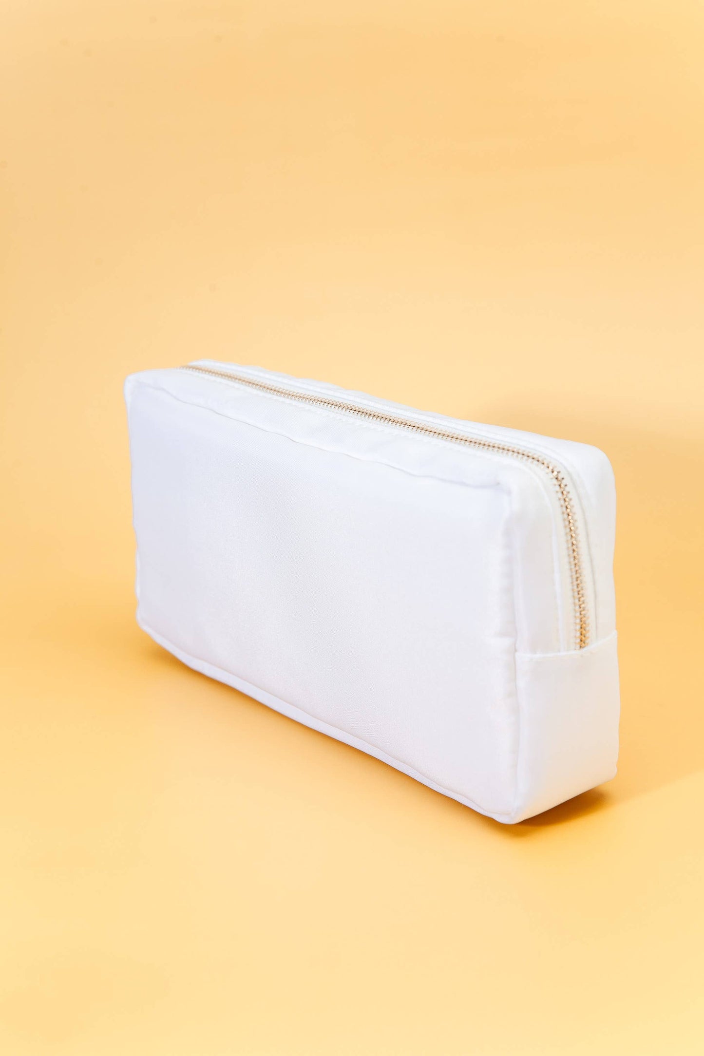 Small nylon cosmetic bag with gold-tone hardware and a zip closure, ideal for travel and everyday organization. 6 colors to choose from: Black, Green, Blue, Peach, White, Pink. 