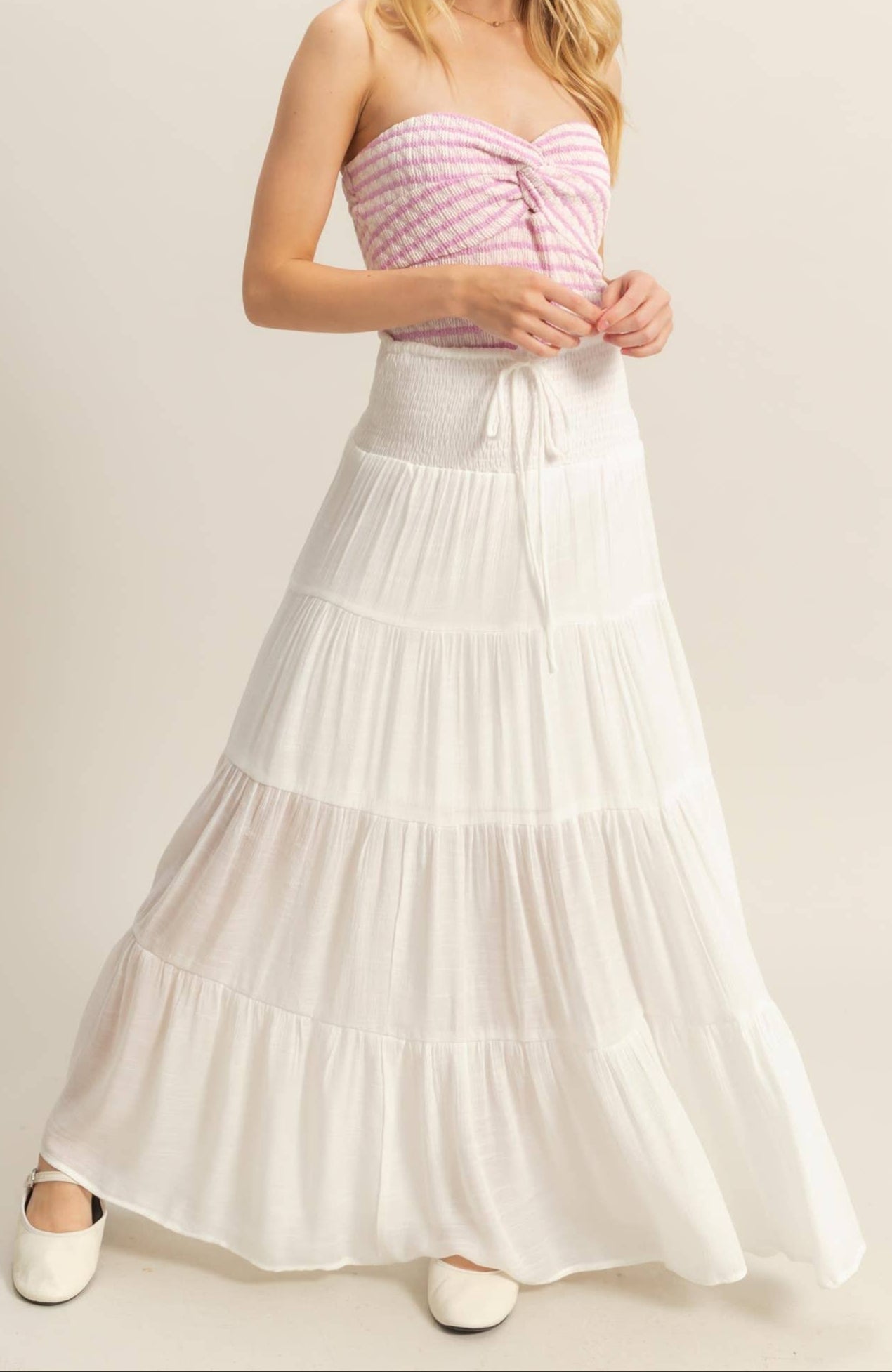 White tiered maxi skirt with a smocked elastic waistband and ankle-skimming hem.