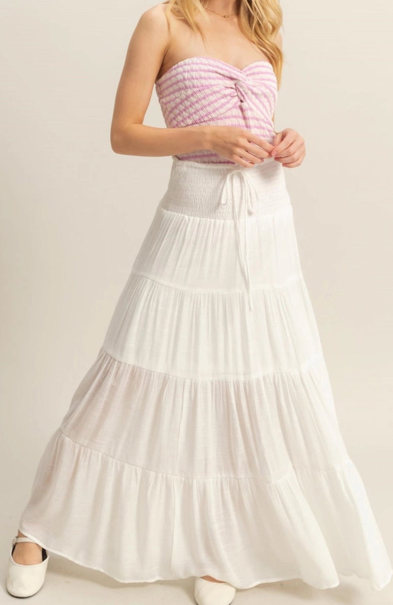 White tiered maxi skirt with a smocked elastic waistband and ankle-skimming hem.