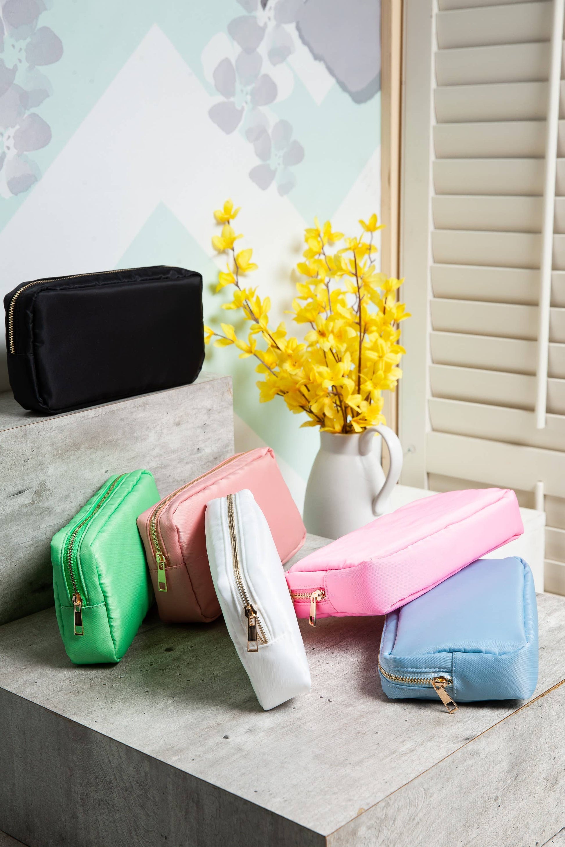 Small nylon cosmetic bag with gold-tone hardware and a zip closure, ideal for travel and everyday organization. 6 colors to choose from: Black, Green, Blue, Peach, White, Pink. 