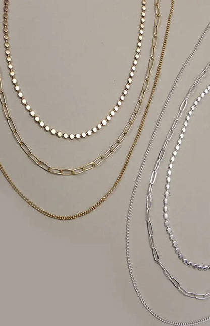 Silver multi-layer chain necklace with three distinct chains and adjustable length.