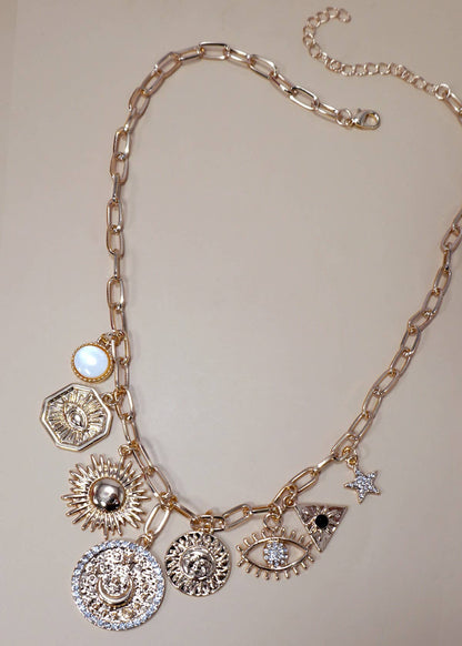 Gold charm necklace featuring celestial charms—sun, moon, stars, and evil eye—with rhinestone accents.